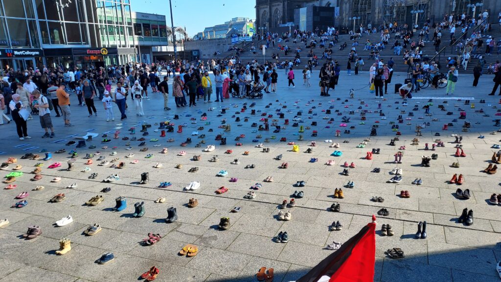 Platz vor dem HBF mit Kinderschuhen und Zuschauern