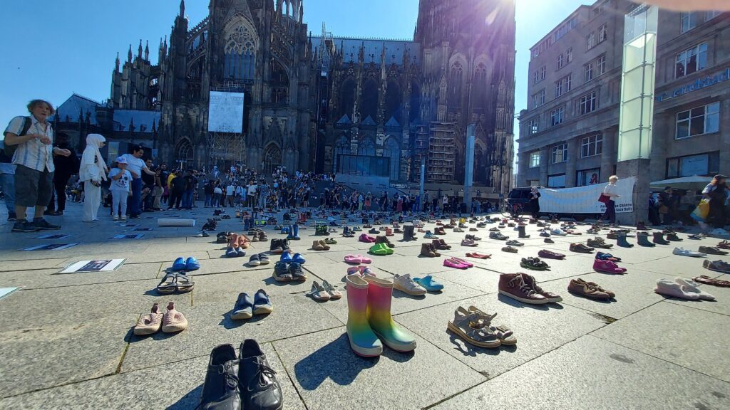 Platz vor dem HBF mit Kinderschuhen und der Dom im Hintergrund