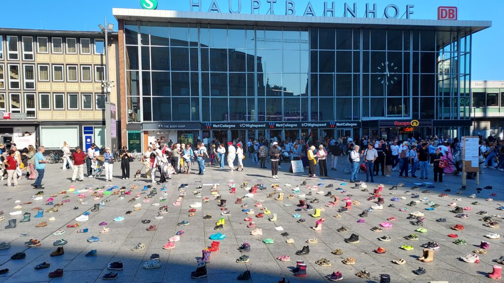 Platz vor dem HBF mit Kinderschuhen und Zuschauern